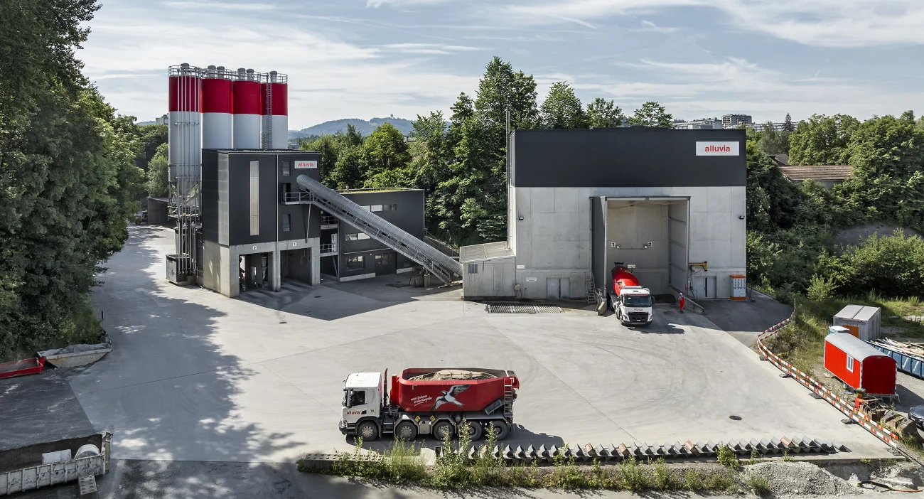 Betonwerk Bern-Bethlehem. Graue Betonzentrale und Kiessilos und rot-weisse Zementsilos.